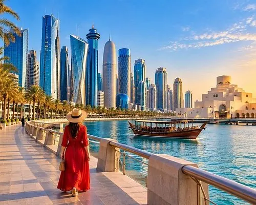 Visitor in a red dress on a waterfront promenade with a wooden dhow and Doha skyline