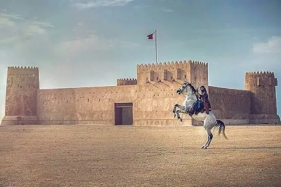 Traditional Qatari fort with a horse rider on a Qatar heritage discovery tour