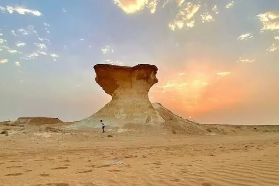 Mushroom-shaped limestone rock formation in the Zekreet desert at sunset on the West Qatar art and desert tour