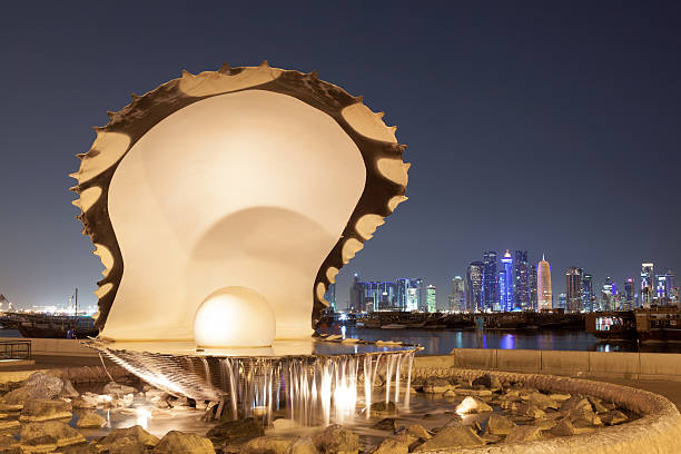 Doha, Qatar - Nov 18, 2015: Pearl and Oyster fountain illuminated at night at the corniche of Doha. Qatar, Middle East